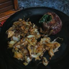 A picture of Stuffed Pinwheel and fried cabbage.