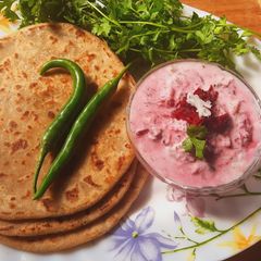 A picture of Matar Paneer Paratha With Beet Root Raita.