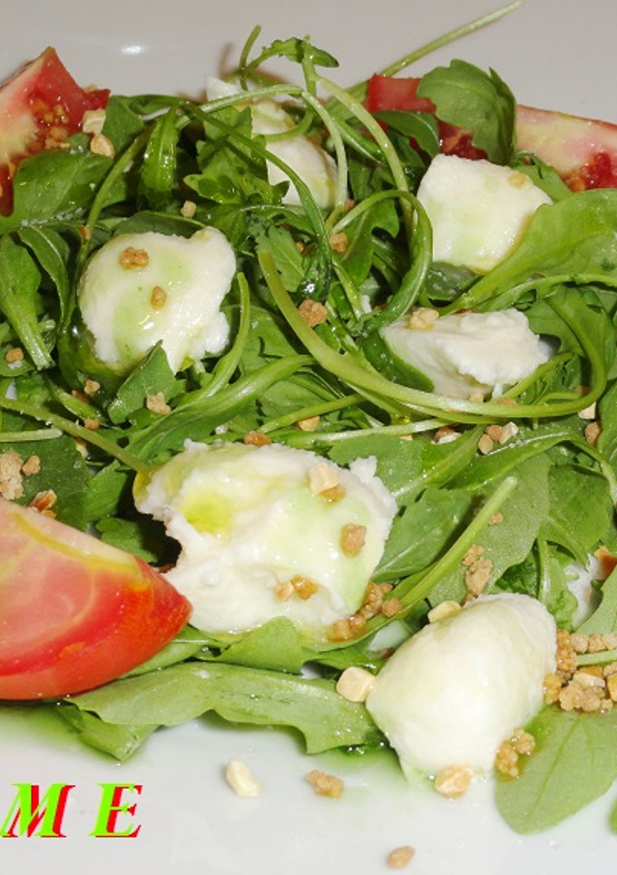 Una foto de Ensalada de rúcula y tomate con queso mozzarella
