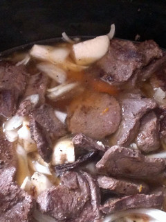 A picture of Deer steak With potatoes onions carrots.