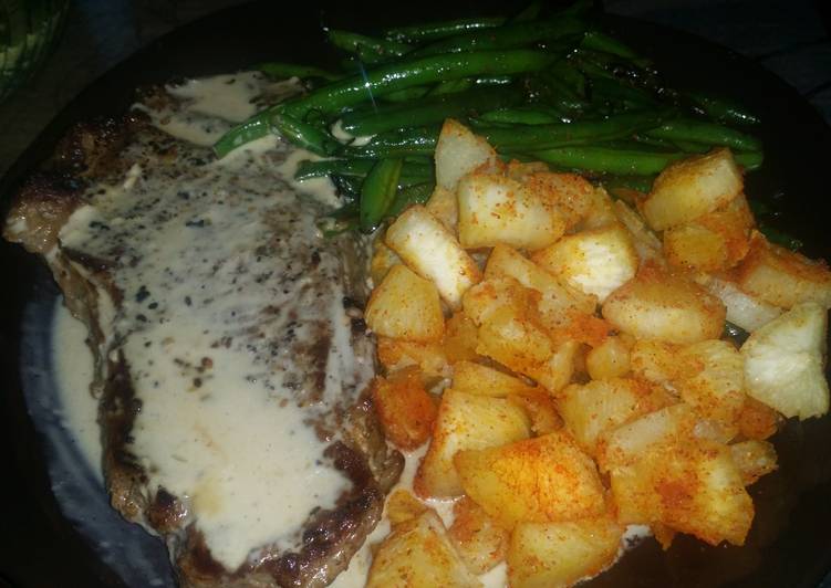 New York Steak with roasted garlic cream sauce, yucca root and stir fried green beans