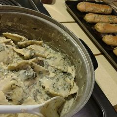 A picture of 4 cheese ravioli & spinach w/ mushrooms.