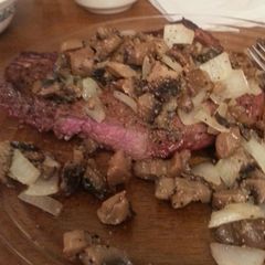 A picture of Grilled steak with sauteed mushrooms and onions.