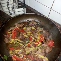 A picture of chicken liver and giblets with sweet peppers and mustard.