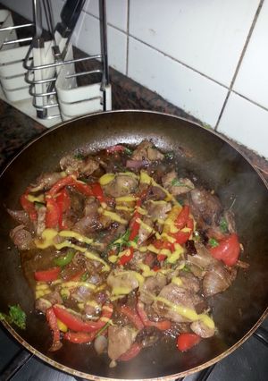 A picture of chicken liver and giblets with sweet peppers and mustard.