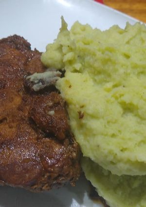 Una foto de T-Bone de cerdo en cerveza roja y puré de papa con crema de apio
