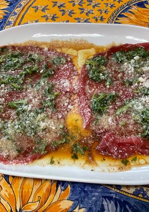 A picture of Beef Carpaccio with Cilantro and Parmesan.