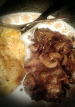 A picture of Smothered Chicken breast with onions and mushrooms & provolone cheese.