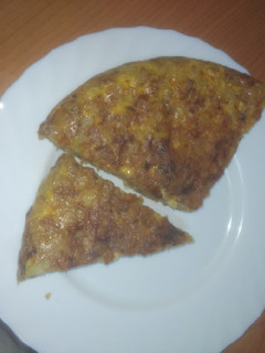 Una foto de Tortilla de papas con cebolla, jamón serrano y panceta