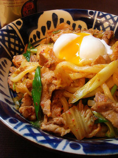 A picture of Stir-fried Pork and Kimchi Udon Noodles with Poached Egg.