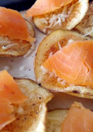 A picture of salmon topped potato crisps.