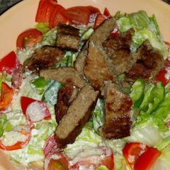 A picture of Caesar saled with beef and a twist.