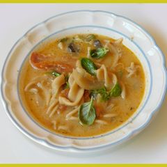 A picture of Spicy, cheesy Tomato, mushroom noodle soup.