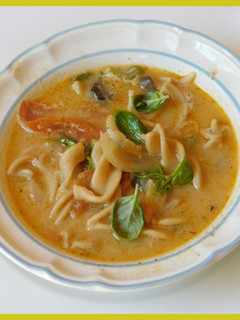 A picture of Spicy, cheesy Tomato, mushroom noodle soup.