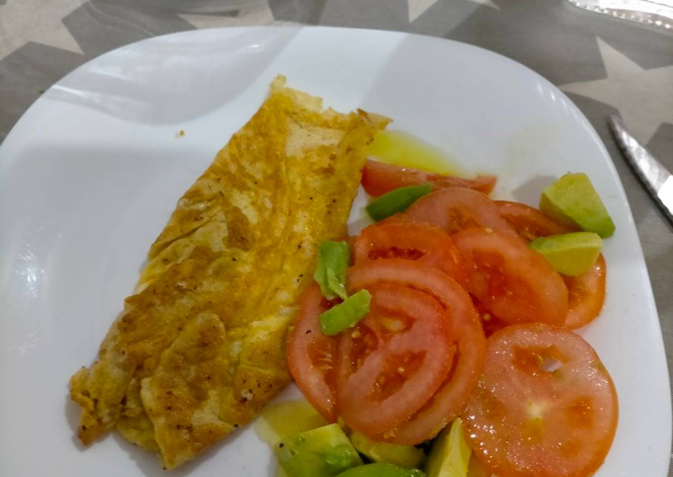 Tortilla francesa con queso rallado y tomate y aguacate