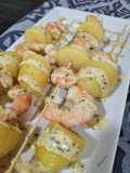 Brocheta de langostinos y patata con salsa al perejil