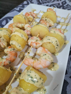 Una foto de Brocheta de langostinos y patata con salsa al perejil