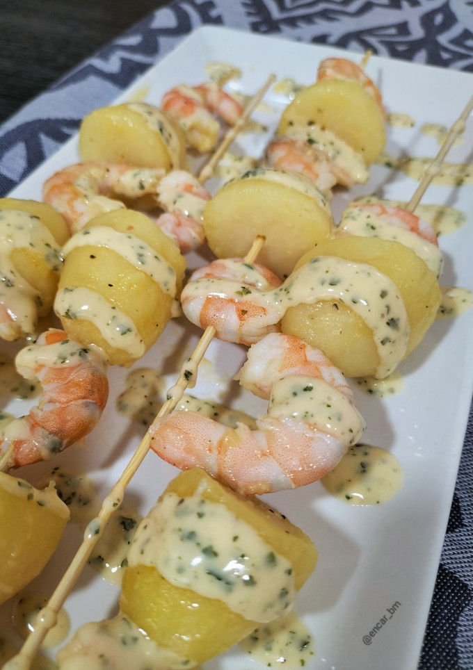 Una foto de Brocheta de langostinos y patata con salsa al perejil
