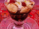 Copa de frutas con queso, nata y salsa de chocolate