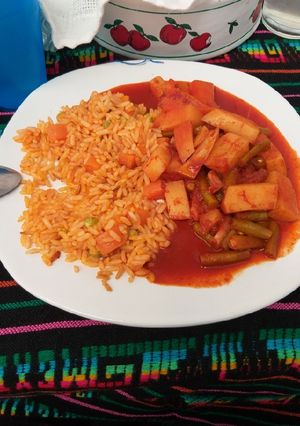 Una foto de Mixiote de verduras con arroz rojo