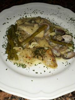 Una foto de Merluza en salsa con espárragos verdes y almejas