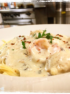 A picture of Shrimp and Scallops Shiitake, Mushroom, Bacon Cream Sauce over Pasta.