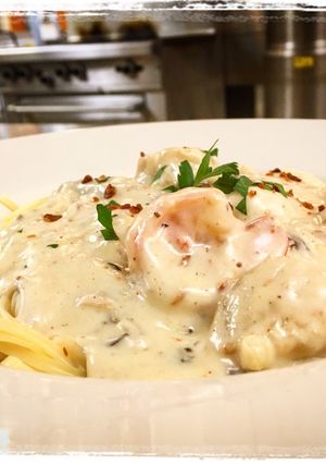 A picture of Shrimp and Scallops Shiitake, Mushroom, Bacon Cream Sauce over Pasta.