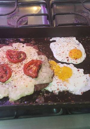 Una foto de Hamburguesa picante a la chapa con papas y huevo frito