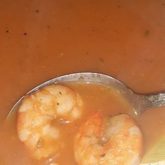 A picture of Tomato and shrimp tails soup.