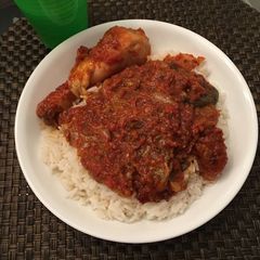 A picture of White rice with pepper stew and chicken.