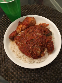 A picture of White rice with pepper stew and chicken.
