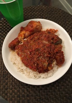 A picture of White rice with pepper stew and chicken.