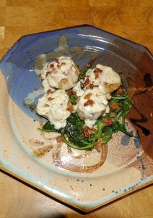 A picture of Seared Scallops with Wine Cream Sauce on Wilted Spinach.