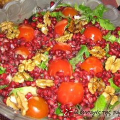 A picture of Arugula salad with pomegranate and spinach.