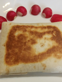 Una foto de Piadina de pollo con calabacín y tomate cerrada