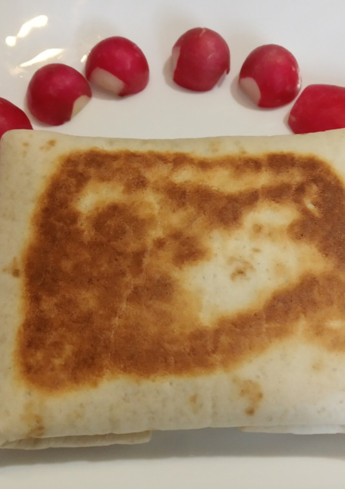 Una foto de Piadina de pollo con calabacín y tomate cerrada