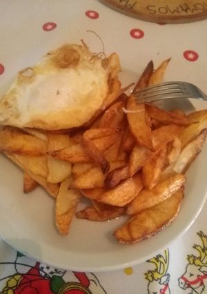 Una foto de Papas fritas con huevo frito