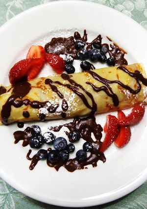 Una foto de CREPES O PANQUEQUES DE ARÁNDANOS, FRAMBUESAS, FRUTILLAS CON SIROPE DE CHOCOLATE