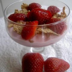 A picture of Yogurt dessert with strawberries and honey.