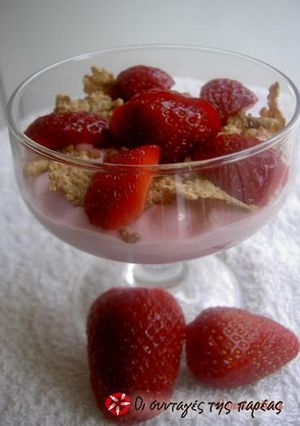 A picture of Yogurt dessert with strawberries and honey.