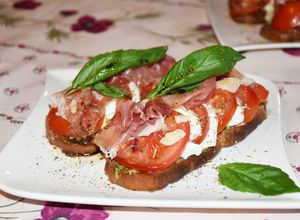 Une photo de Bruschettas au pesto, tomates, mozzarella et jambon cru
