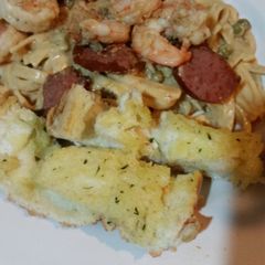 A picture of Shrimp & sausage scampi with sweet peas.