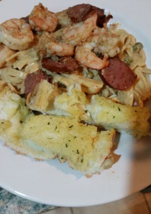 A picture of Shrimp & sausage scampi with sweet peas.