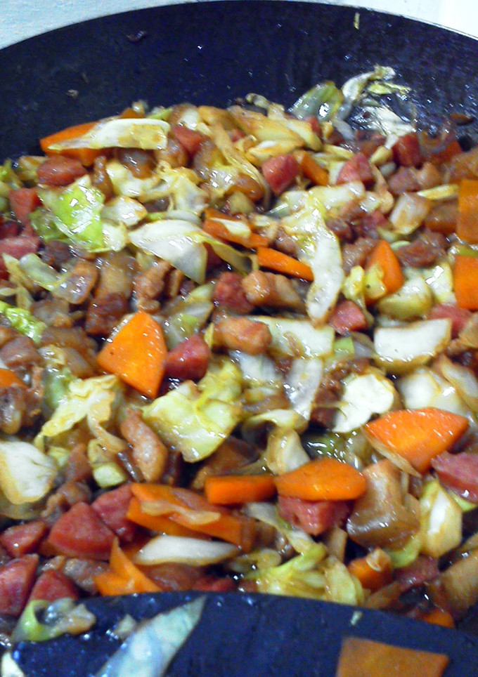 A picture of stir-fry pork with cabbage and carrots.
