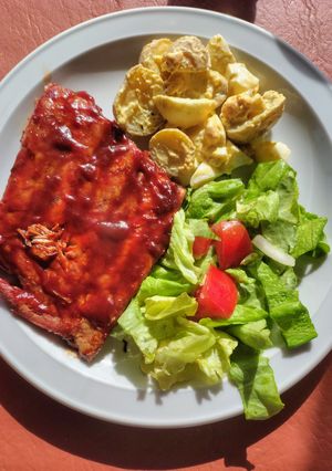 Una foto de Ribs de cerdo con ensaladas mixta y de papines y huevo