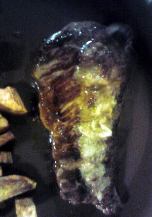 A picture of Steak w/ Roasted Garlic Butter and Lemon.