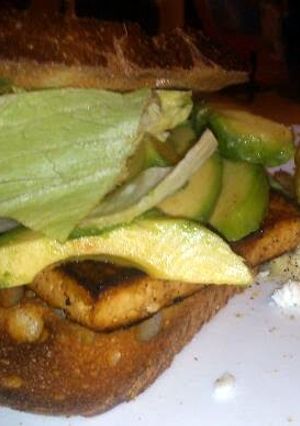 A picture of grilled tofu sandwich with avo & Bacon.