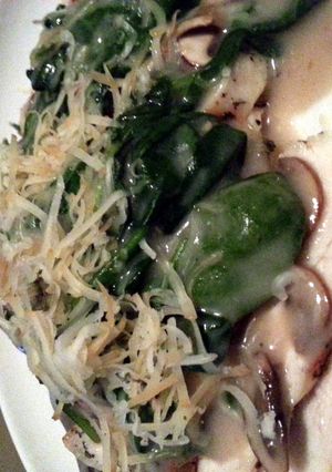 A picture of Creamy mushroom and spinach over grilled chicken breast.