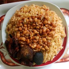 A picture of Jollof rice with honey beans.