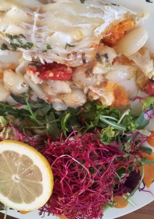 A picture of cod with stuffing and salad.